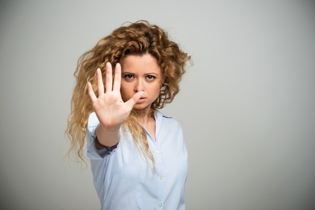 Foto donna che fa un segnale di stop con la sua mano