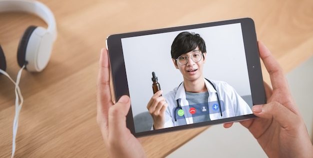 Woman making video call to doctor on tablet and provide help online counseling. Concept working from home.