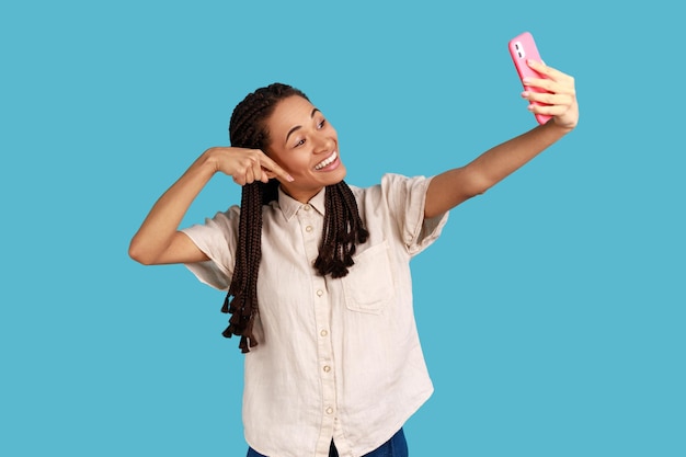 Woman making video call or online streaming using phone pointing finger down asking to follow