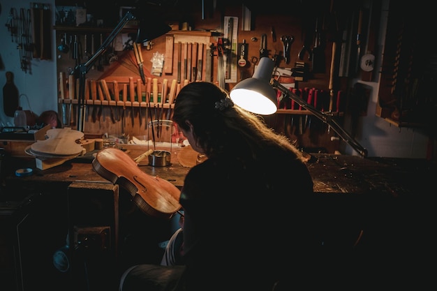 Photo woman making violin in darkroom