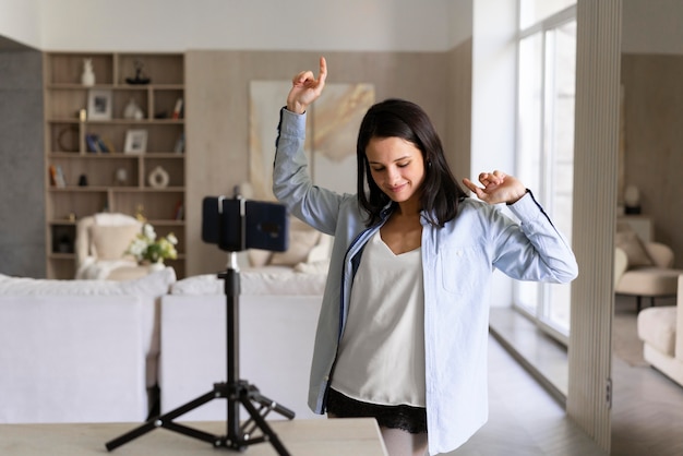 Foto donna che fa un vlog a casa con il suo telefono