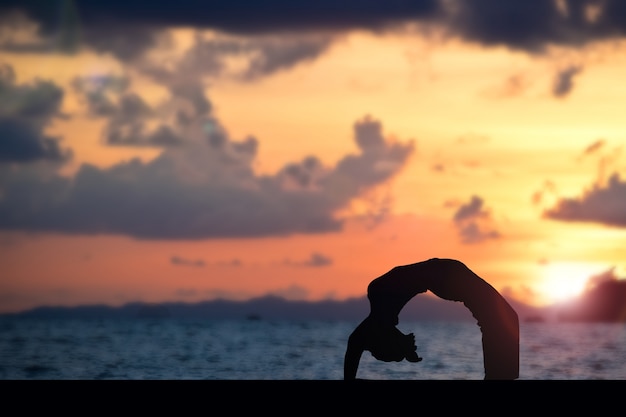 Woman making yoga on the beach