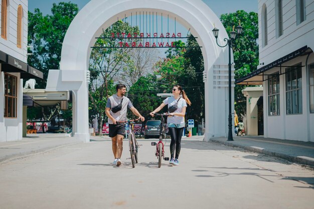 Photo woman and man on bicycle at the market