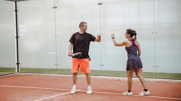 Woman and man celebrating a point on a paddle court