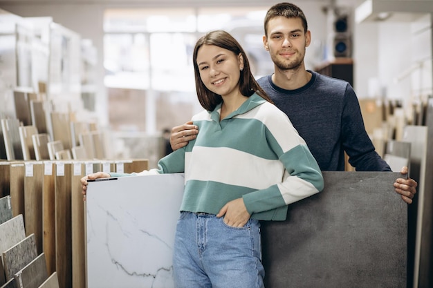 Photo woman and man choosing tiles at building market