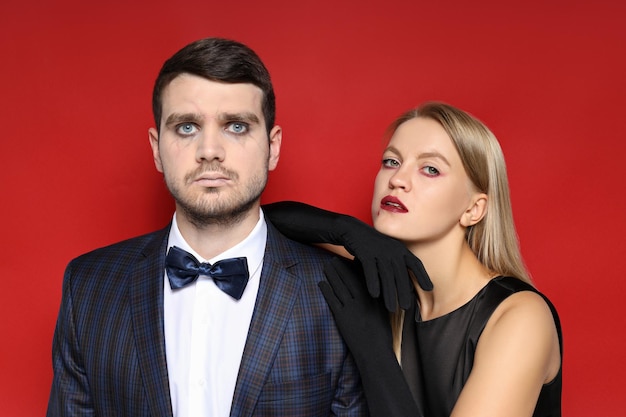 A woman and a man in Halloween costumes on a red background