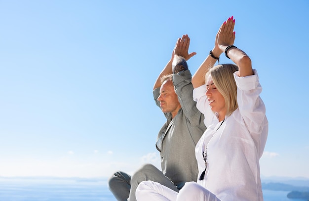 Женщина и мужчина практикуют медитацию на открытом воздухе