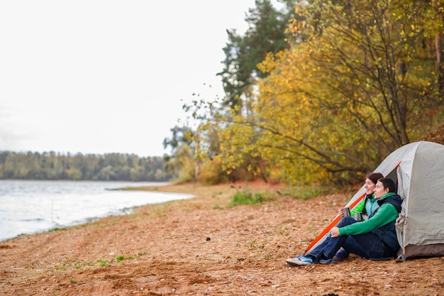 Woman and man sitting near tent