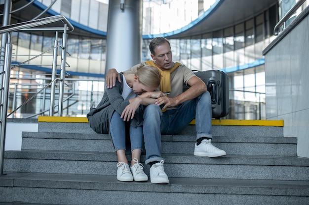 Woman and man sitting on stairs in terminal