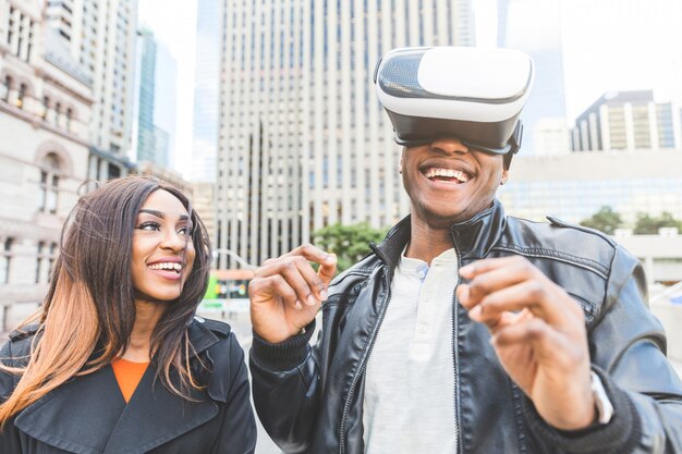 Woman and man smiling as he tries virtual reality headset