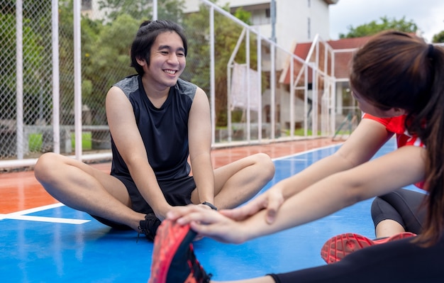 屋外で運動するストレッチ運動をしている女性と男性のスポーツカップル