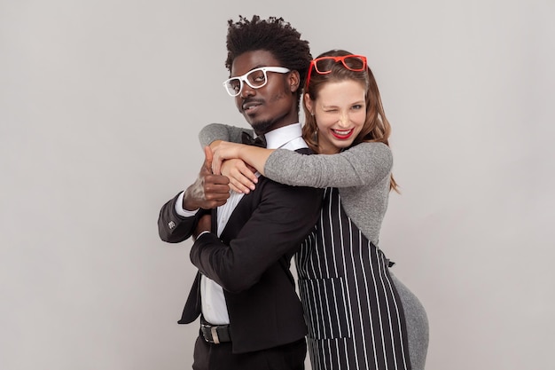 Woman and man standing together guy showing thumb up female winking playfully to camera