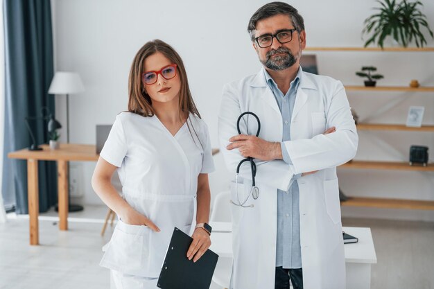 Woman and man standing together Professional medical workers in white coats is in the office