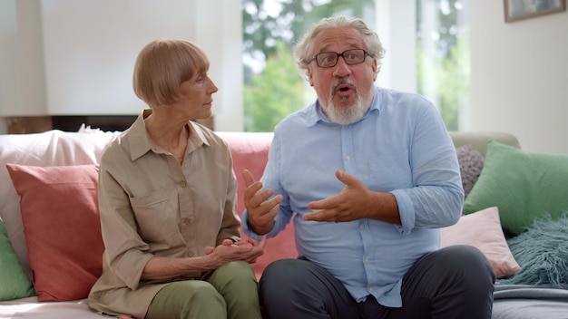 Woman and man talking in room Grandparents greeting grandchildren at home