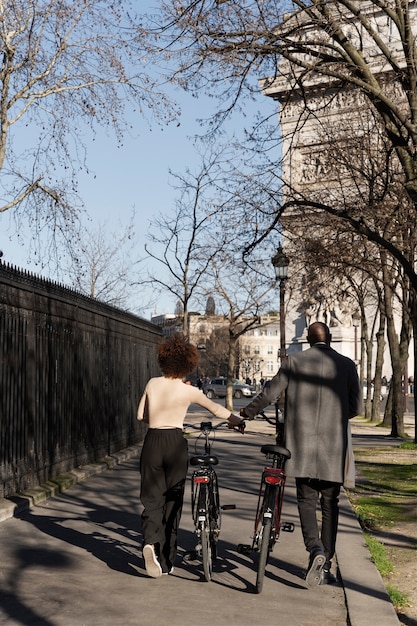 Photo woman and man walking with bikes in the city in france