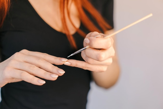 Женщина во время маникюра Крупным планом женщина красит ногти лаком для ногтей