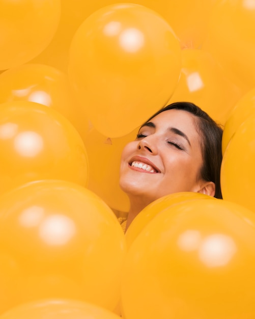 Foto donna tra molti palloncini gialli