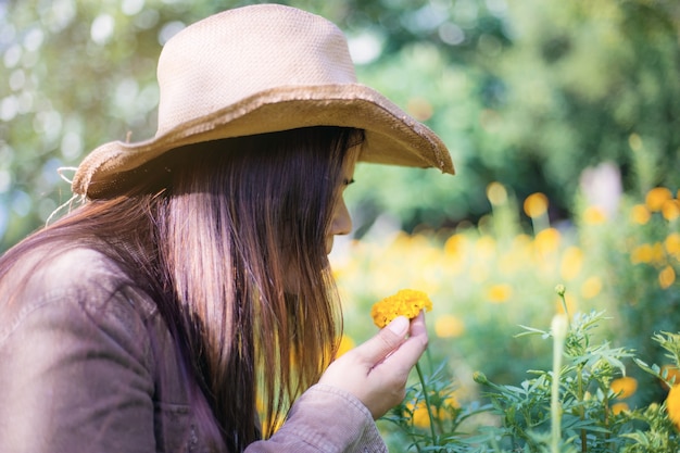 Woman and marigold flower in garden.