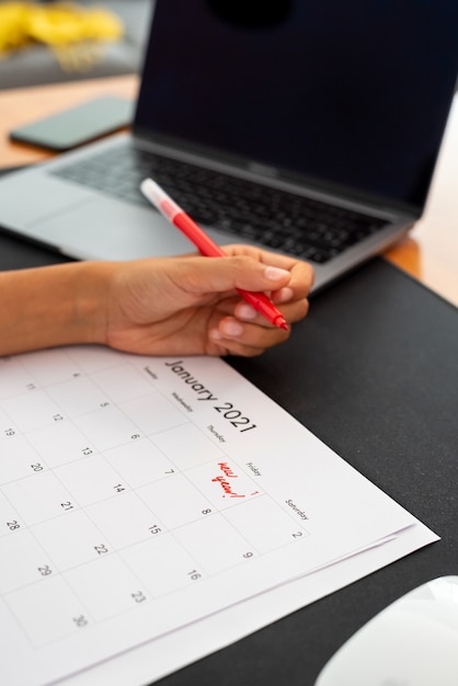 Foto donna che segna il primo gennaio su un calendario