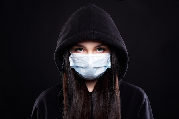 Woman in Mask and Hood Girl in medicine Mask and Hoodie covid19