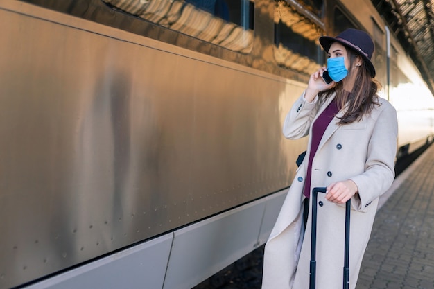 Woman in mask is talking on the phone