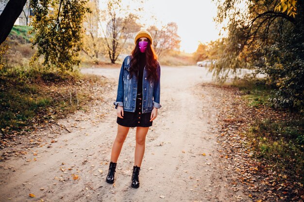 Photo woman in a mask stands on the street