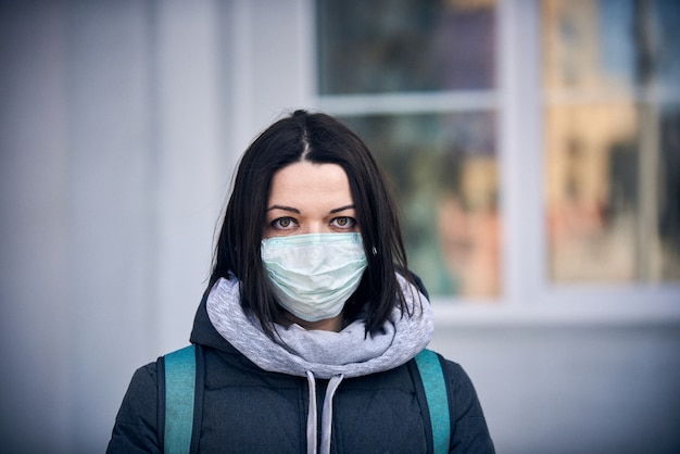 Photo woman in mask on street because epidemic of coronavirus in city.