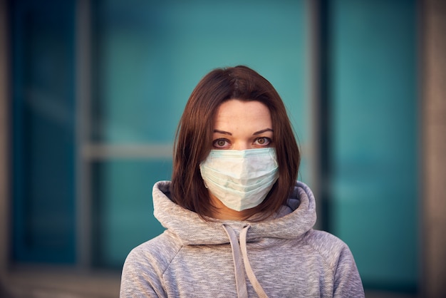 Woman in mask on street because epidemic of coronavirus in city.