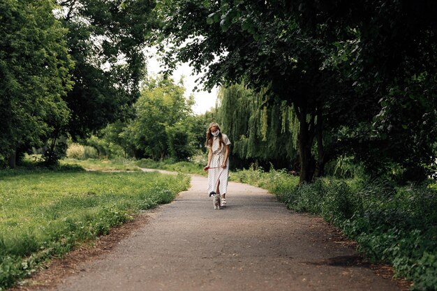 Woman in a mask walks with a cat