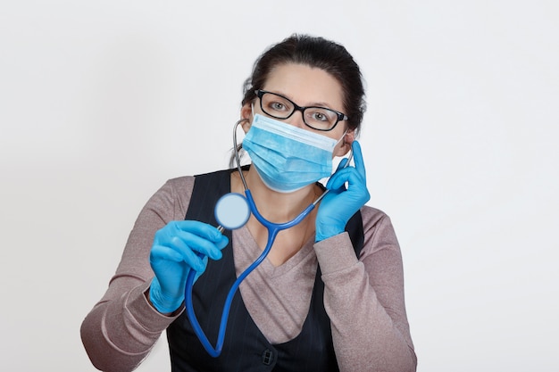 Woman in a mask with a phonendoscope in her hands