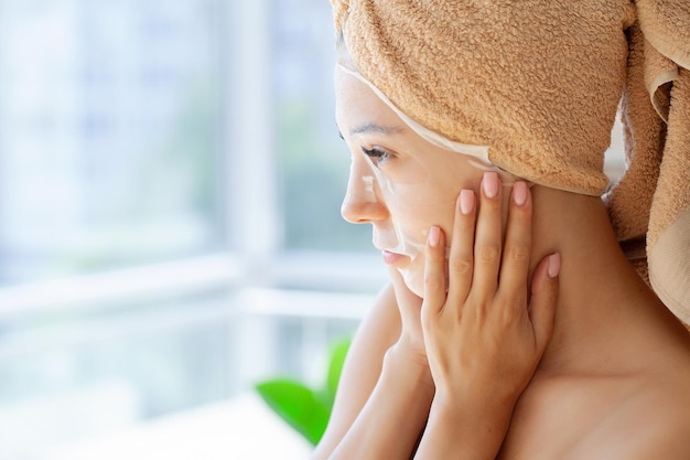 Woman in a mask with a towel on her head skin care cosmetology