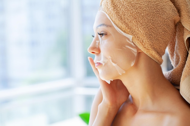 Woman in a mask with a towel on her head skin care cosmetology