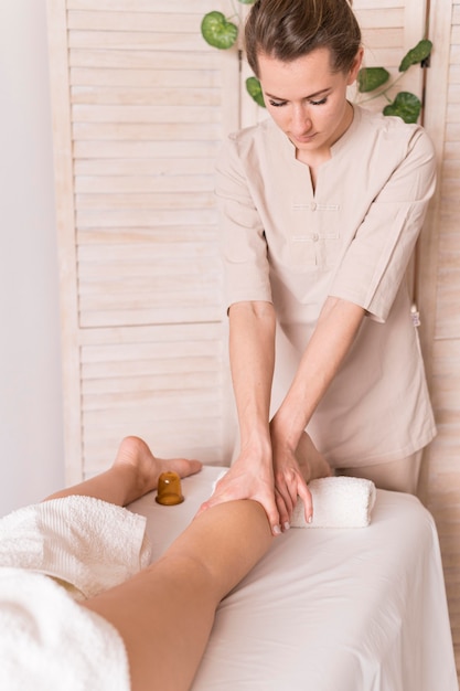 Foto donna che massaggia la gamba del cliente