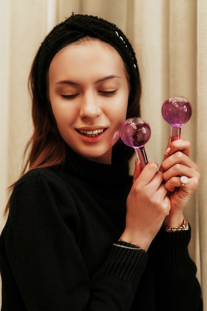 Woman massaging her face with Facial Ice Globes.