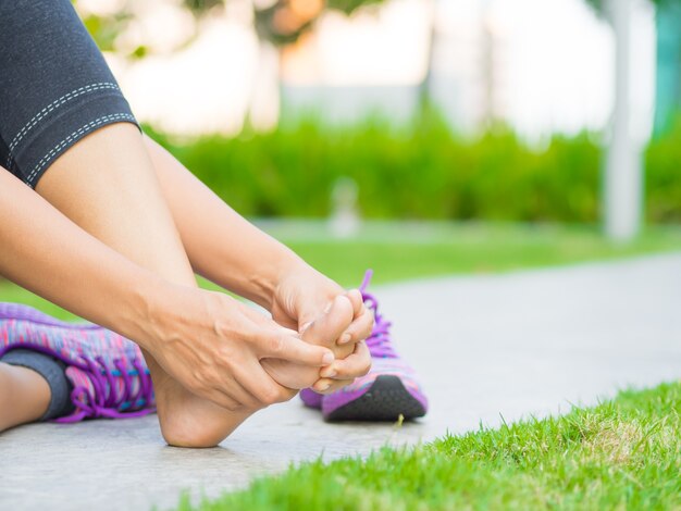 Woman massaging her painful foot. 