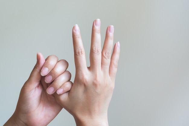 Donna che massaggia la sua mano dolorosa.