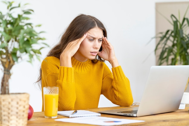 Woman massaging temples of head due to headache from long work