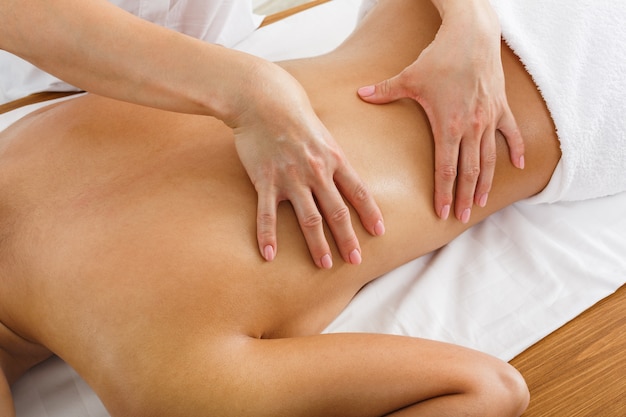 Фото Женщина-массажист делает массаж тела в оздоровительном спа-центре