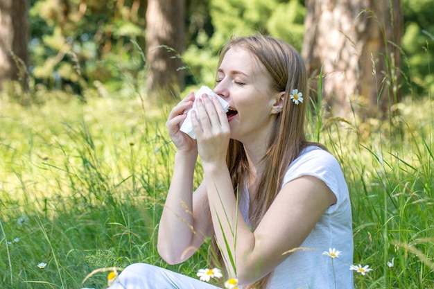 牧草地の女性がくしゃみをする、アレルギーの概念
