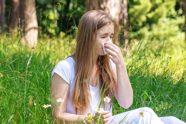 Photo woman in the meadow sneezes