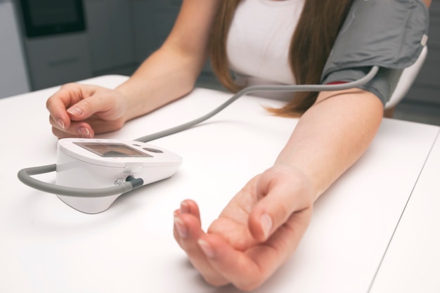 woman measures blood pressure at home