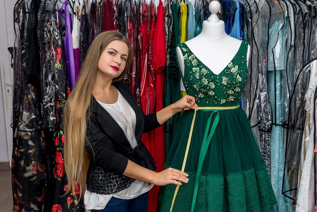 Woman measuring beautiful evening dress with meter