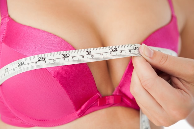 Woman measuring chest in pink bra