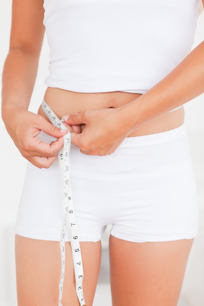 Woman measuring her belly