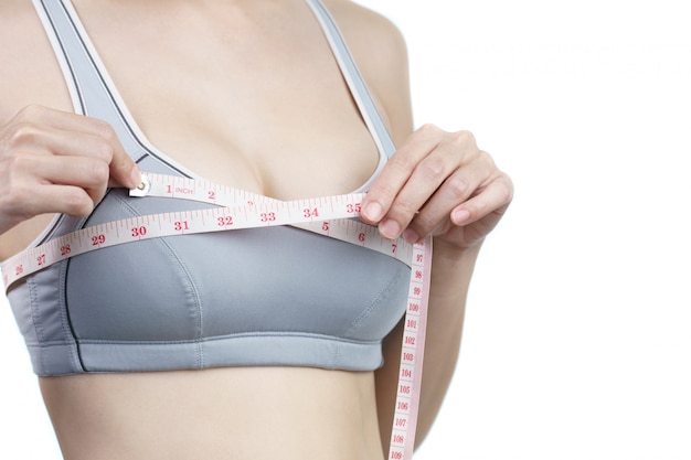 Woman measuring her chest for breast implant surgery.