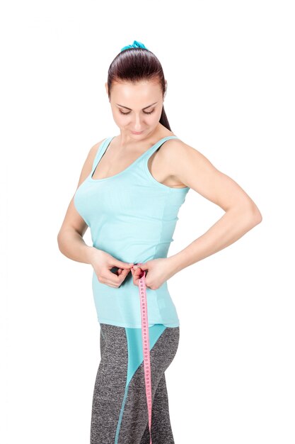 Photo woman measuring her hips with tape measure.