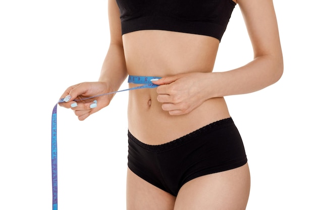 Photo woman measuring waist with blue measuring tape.