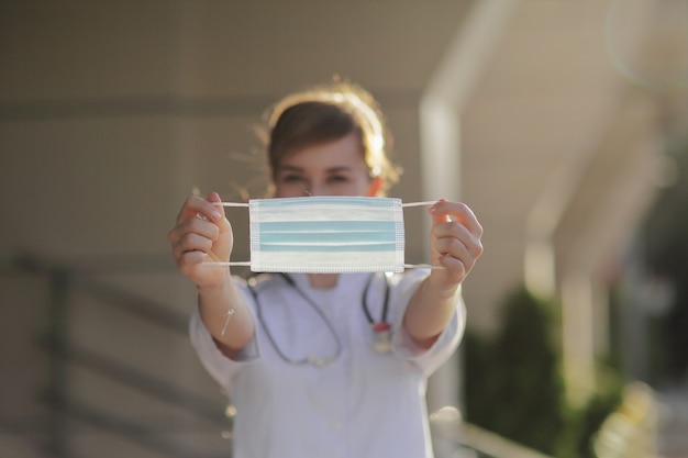 Woman medic holding a medical protective mask