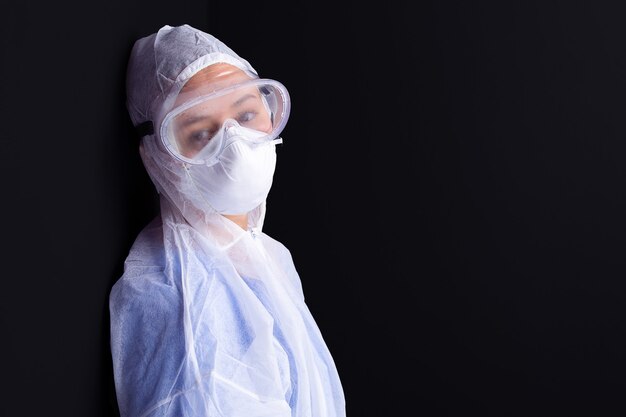 Woman in medical equipment and medical glasses with tired look posing on camera in pandemic time