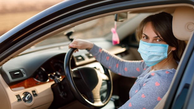 Woman in the medical mask in car. coronavirus, disease, infection, quarantine, covid-19